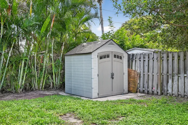 a white house with a small yard and wooden fence