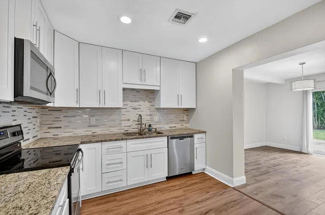 a kitchen with a sink cabinets and wooden floor