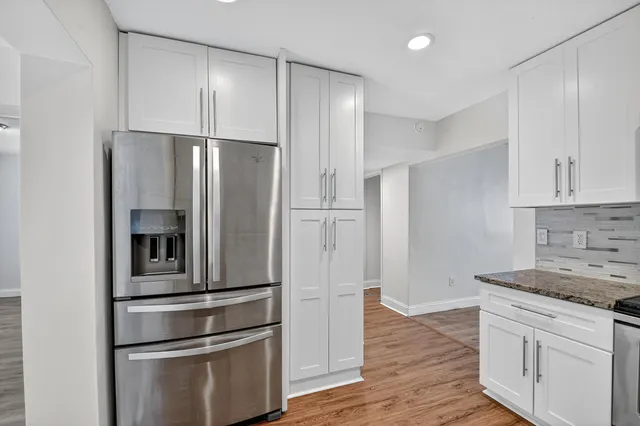 a kitchen with stainless steel appliances granite countertop a refrigerator and a stove top oven