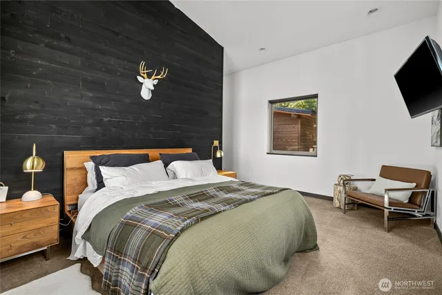 a spacious bedroom with a bed and a flat screen tv