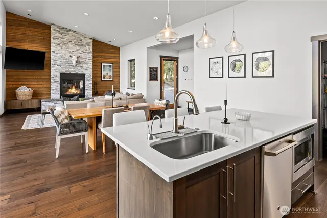 a kitchen island with granite countertop a sink and a refrigerator