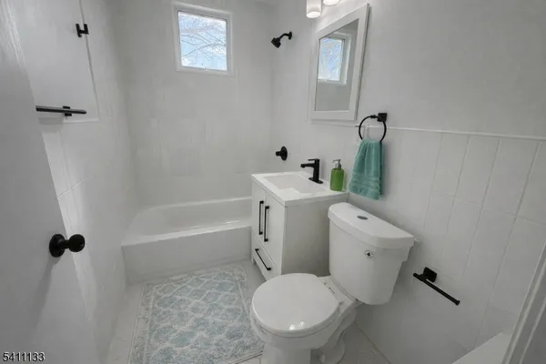 a white toilet sitting next to a bath tub