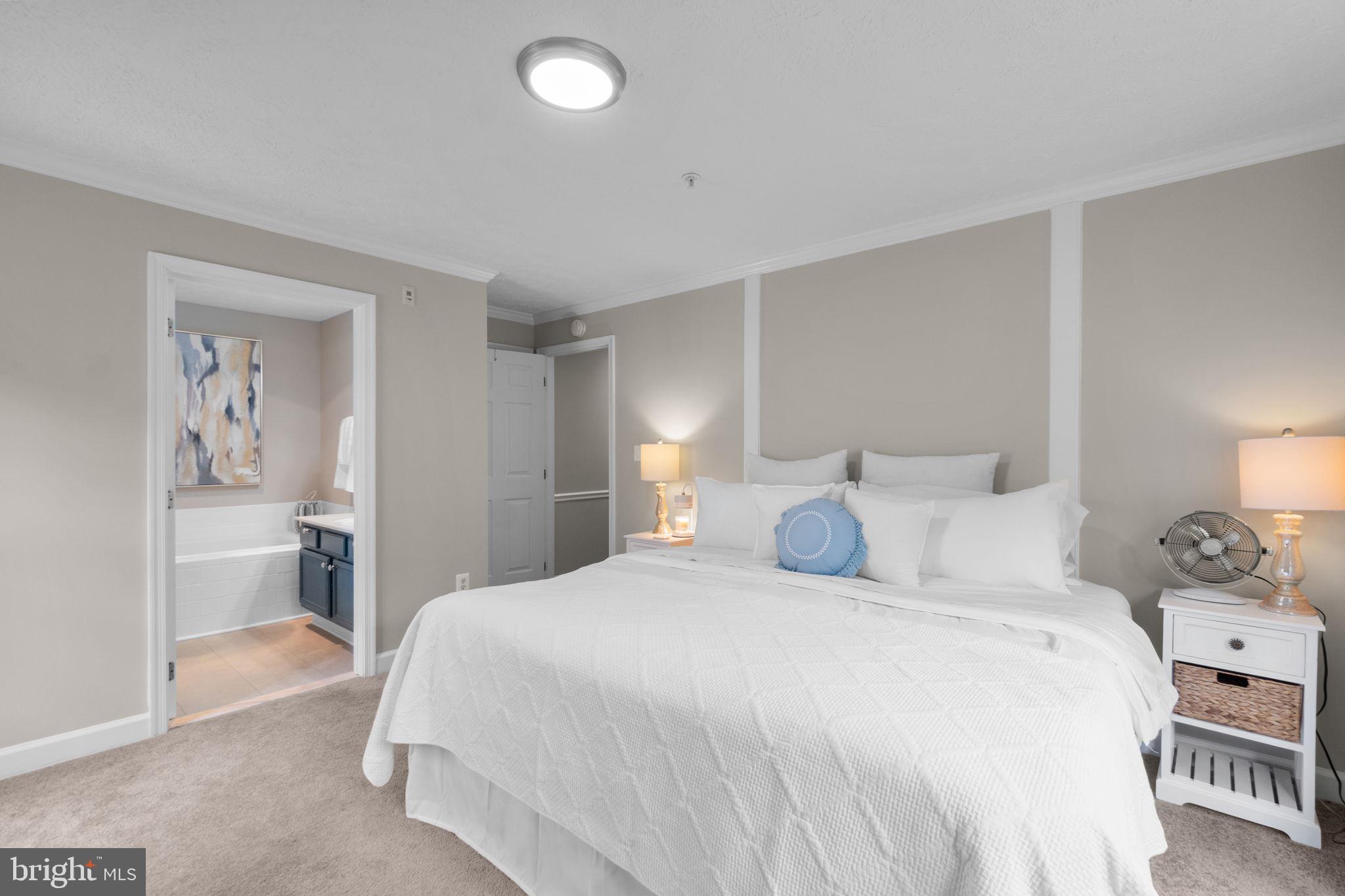 6509 Springwater Court, Unit 6303 Frederick, MD 21701 - Photo 20 of 48 a bedroom with a bed and a lamp