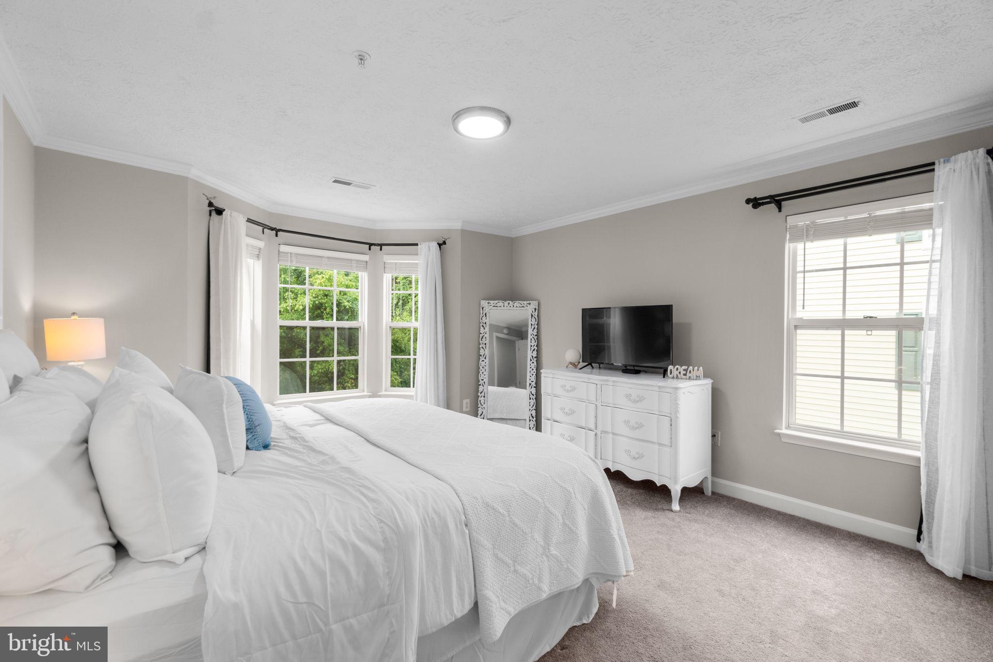 6509 Springwater Court, Unit 6303 Frederick, MD 21701 - Photo 22 of 48 a bedroom with a bed and a flat screen tv