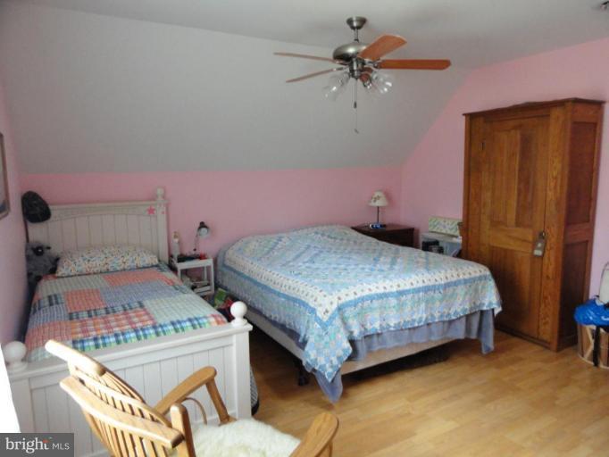 8235 Detour Road Denton, MD 21629 - Photo 16 of 30 a bedroom with a bed and a chandelier