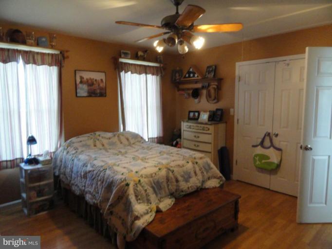8235 Detour Road Denton, MD 21629 - Photo 17 of 30 a bedroom with a bed and a chandelier