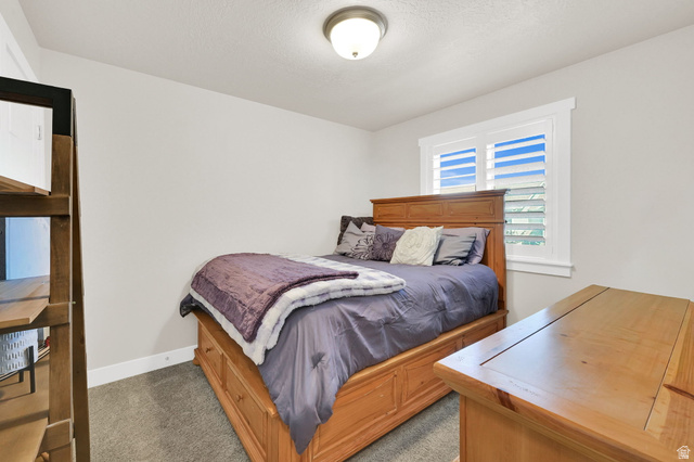 2777 West 4175th Street South, Unit 232 Roy, UT 84067 - Photo 22 of 27 Bedroom 3- featuring a window with plantation shutters, ceiling fan with integrated lighting, carpet and light-toned wall paint
