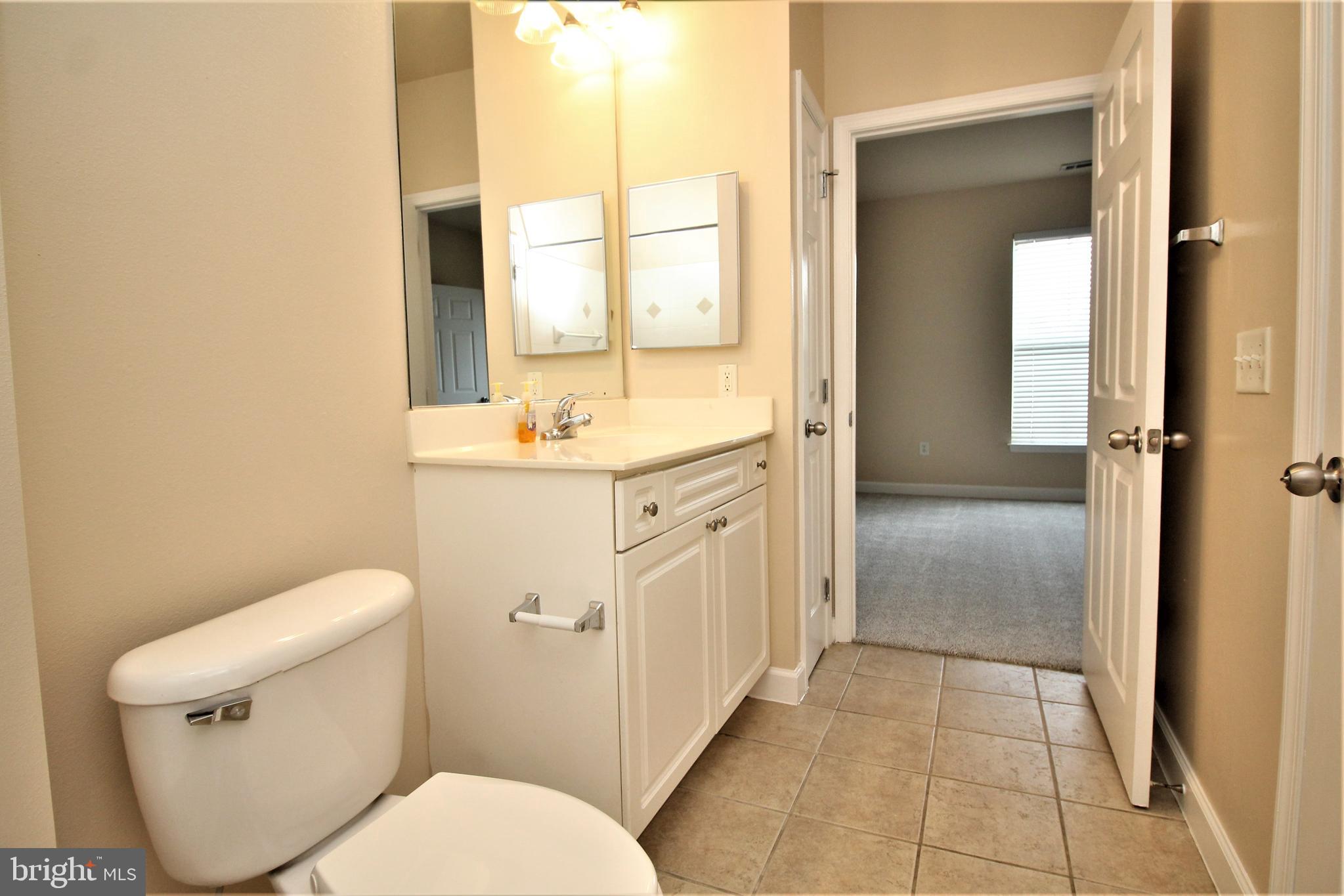 501 Hungerford Drive, Unit 137 Rockville, MD 20850 - Photo 14 of 37 a spacious bathroom with a toilet sink and a mirror