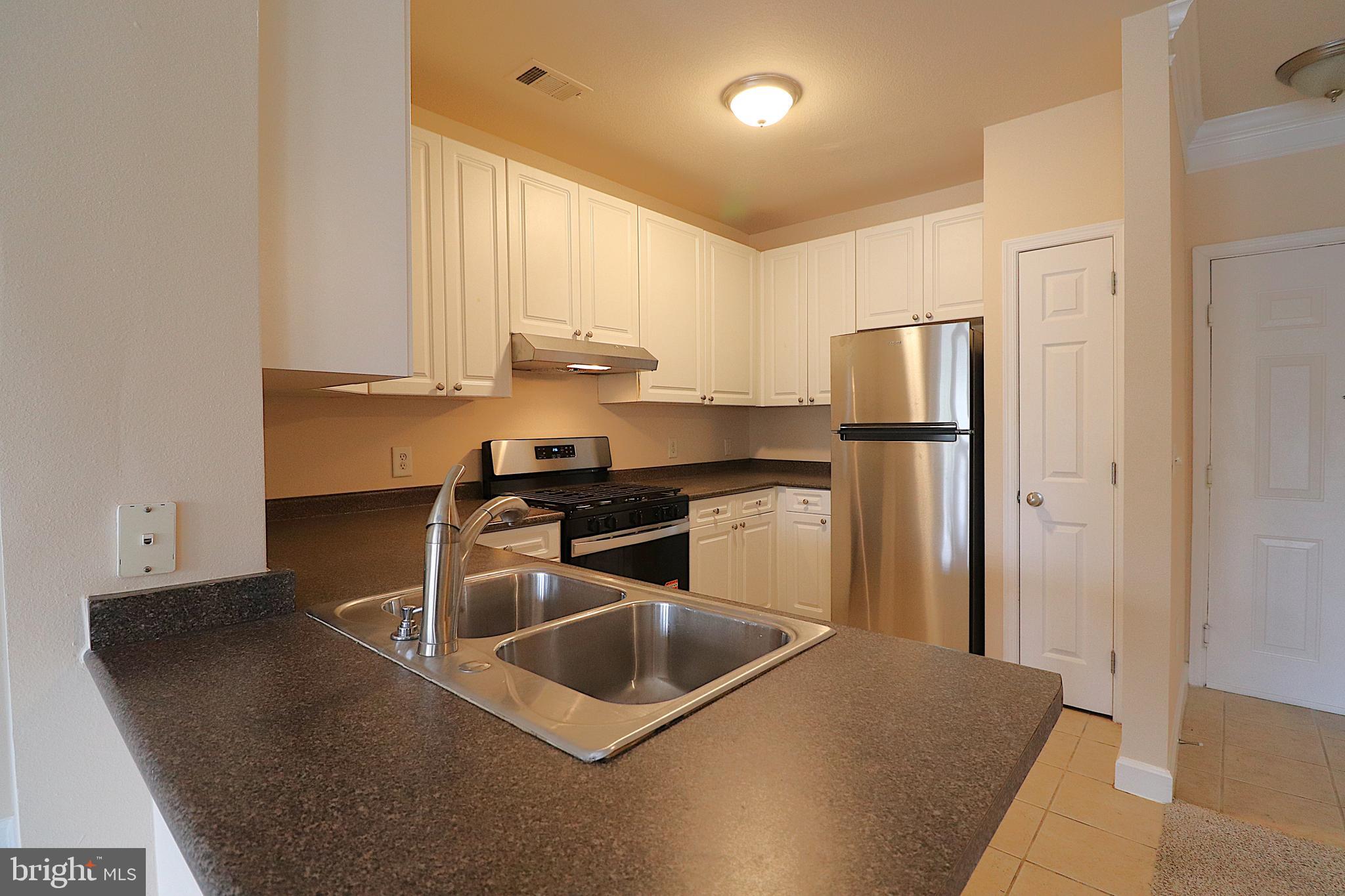 501 Hungerford Drive, Unit 137 Rockville, MD 20850 - Photo 2 of 37 a kitchen with stainless steel appliances a sink a stove a refrigerator a counter top space and cabinets