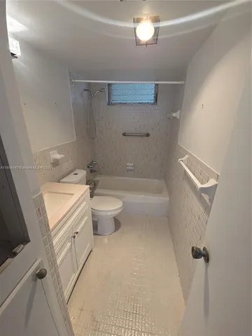 a bathroom with a granite countertop sink a toilet and shower