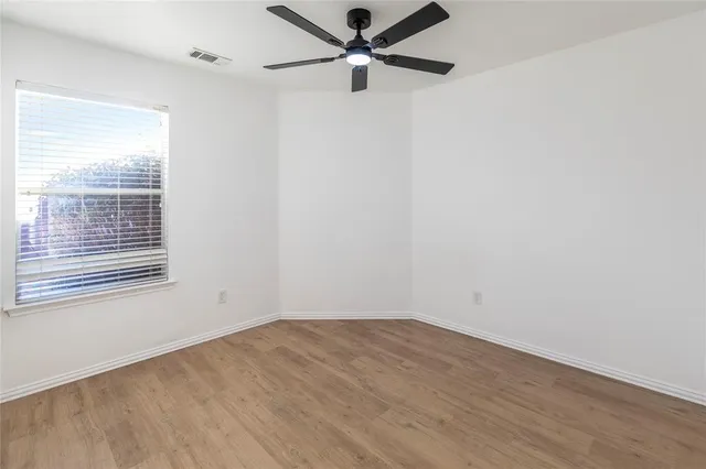 a view of a big room with wooden floor and windows in a room