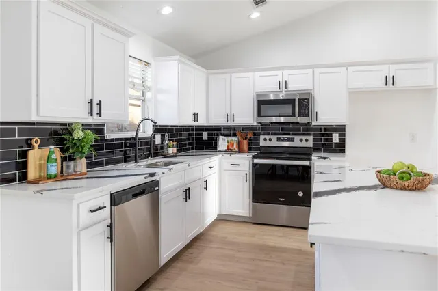 a kitchen with stainless steel appliances white cabinets and a sink
