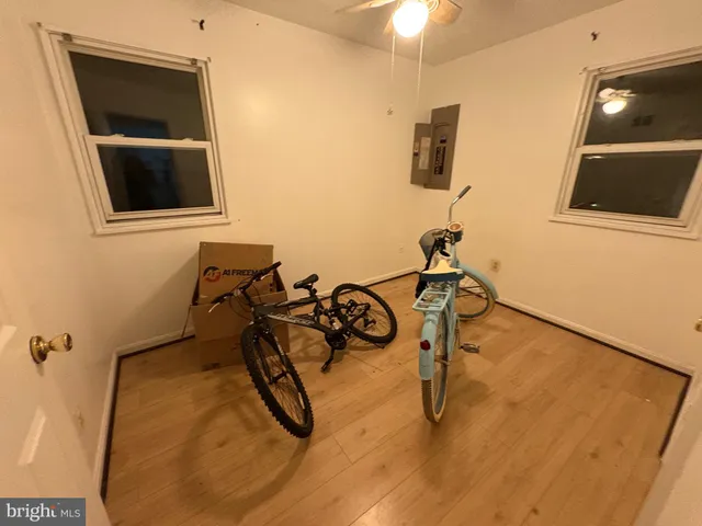 a room with gym equipment and wooden floor