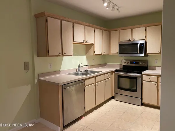 a kitchen with sink a microwave and cabinets