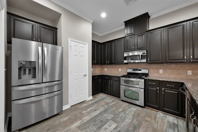 a kitchen with stainless steel appliances granite countertop a refrigerator stove and microwave