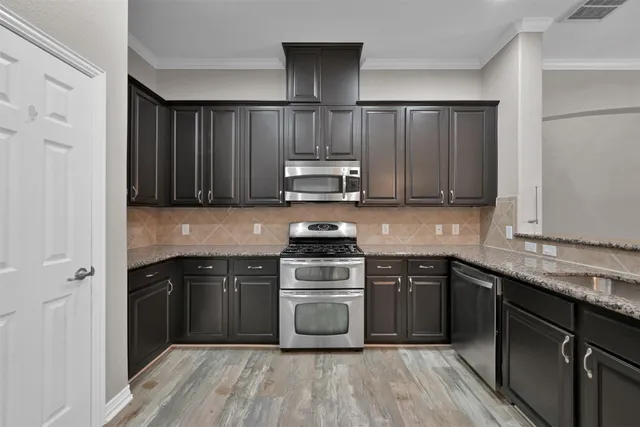 a kitchen with sink cabinets and stainless steel appliances