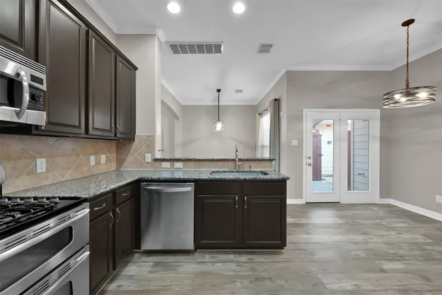 a kitchen with stainless steel appliances granite countertop a stove and a sink