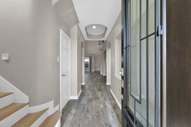 a view of a hallway with wooden floor and staircase