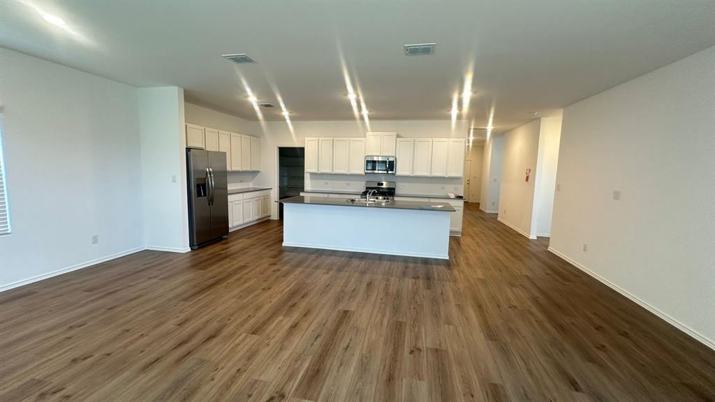 192 Rodney Boat Road Kyle, TX 78640 - Photo 8 of 38 An open-concept living area flows into a kitchen with an island, perfect for entertaining.