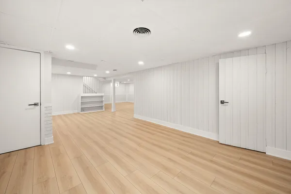 a view of empty room with wooden floor