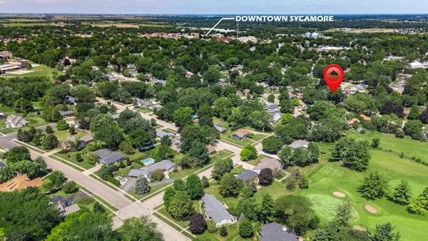 an aerial view of residential houses with outdoor space and trees