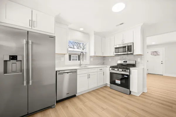 a kitchen with stainless steel appliances a refrigerator sink and microwave