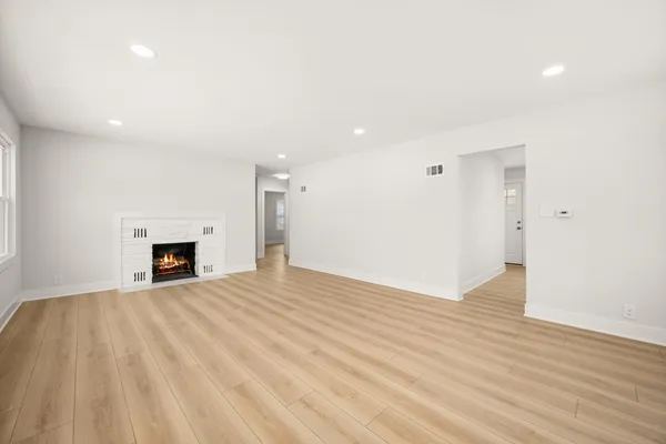 a view of a livingroom with wooden floor and a fireplace