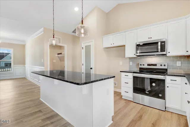 a kitchen with stainless steel appliances granite countertop a stove a sink and a refrigerator