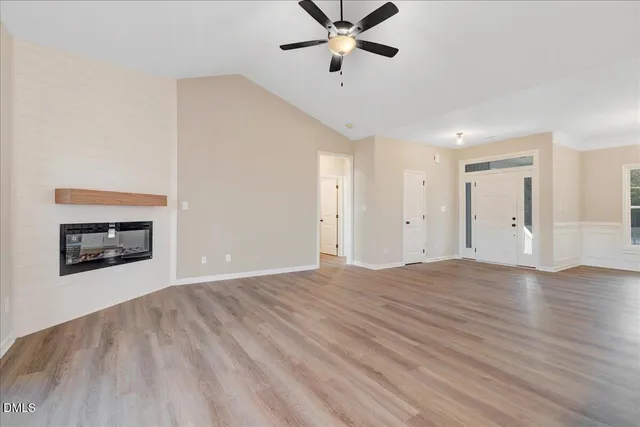 a view of empty room with wooden floor and fireplace