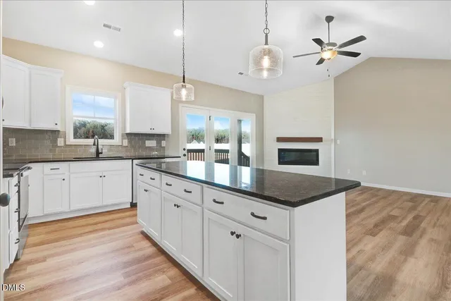 a kitchen with stainless steel appliances granite countertop a sink a stove and a refrigerator