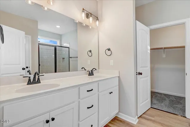 a bathroom with a double vanity sink mirror and shower