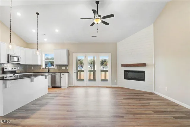 a large kitchen with cabinets wooden floor and a fireplace