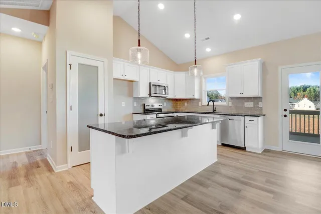 a kitchen with stainless steel appliances granite countertop a sink and a stove top oven