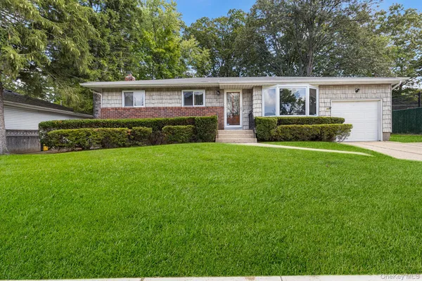 a view of house with a big yard and potted plants