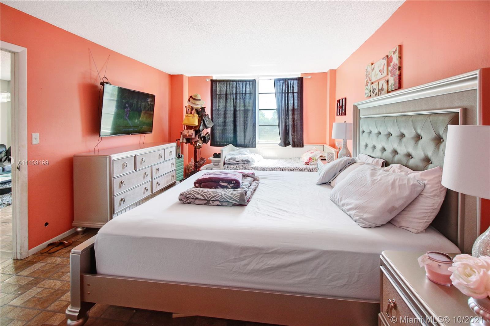 15600 Northwest 7th Avenue, Unit 3011 Miami, FL 33169 - Photo 14 of 30 a bedroom with a bed and a flat screen tv