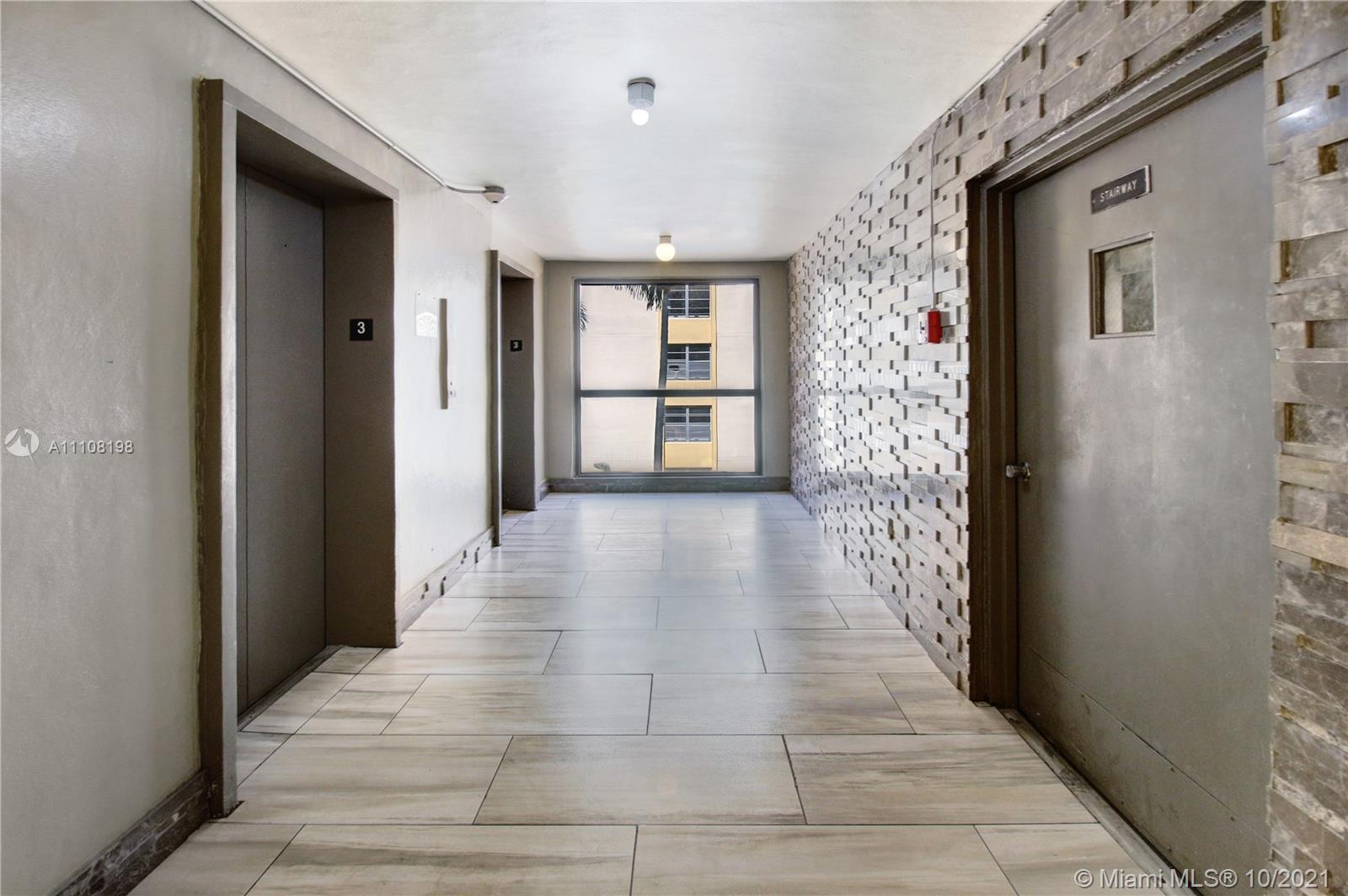 15600 Northwest 7th Avenue, Unit 3011 Miami, FL 33169 - Photo 25 of 30 a view of a hallway with wooden floor and a living room