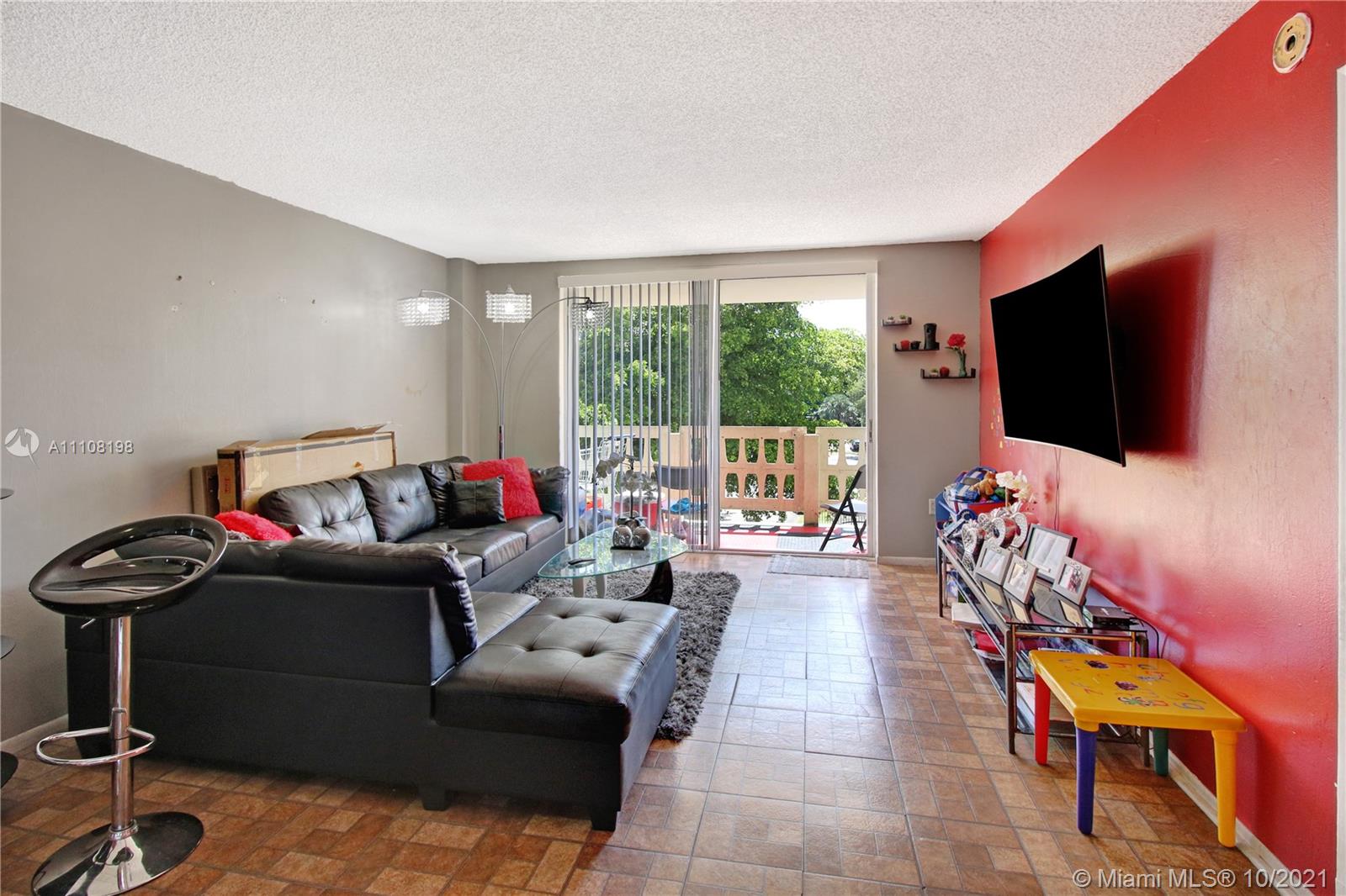 15600 Northwest 7th Avenue, Unit 3011 Miami, FL 33169 - Photo 4 of 30 a living room with furniture and a flat screen tv