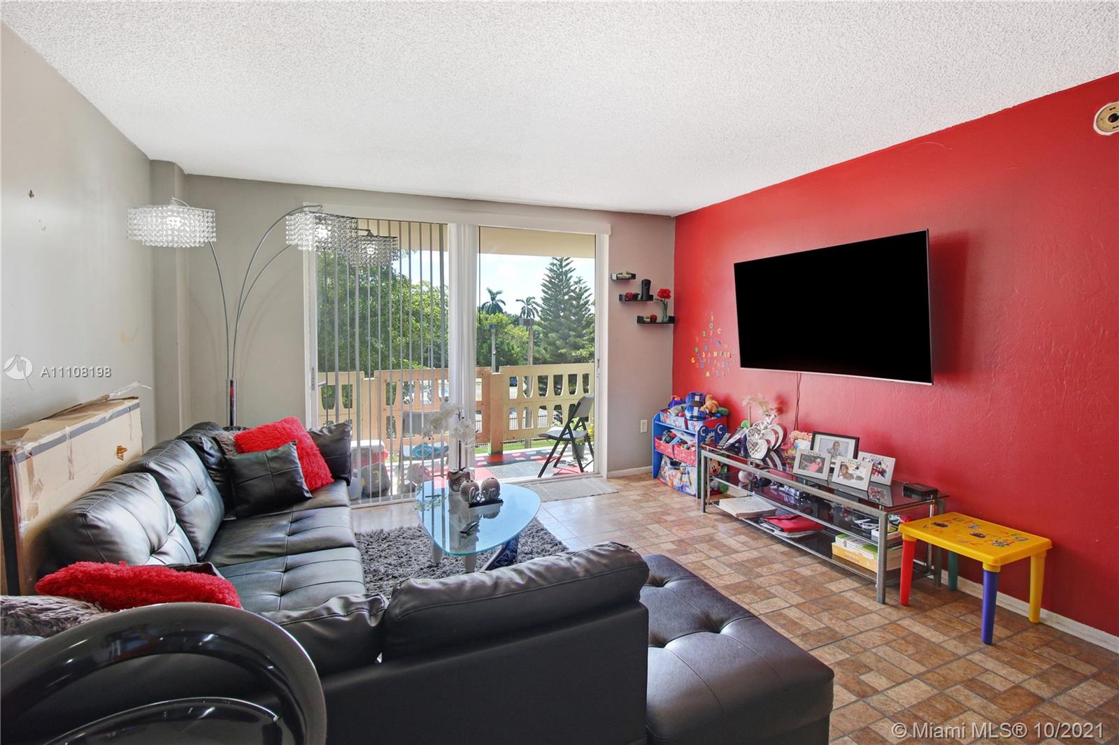 15600 Northwest 7th Avenue, Unit 3011 Miami, FL 33169 - Photo 5 of 30 a living room with furniture and a flat screen tv