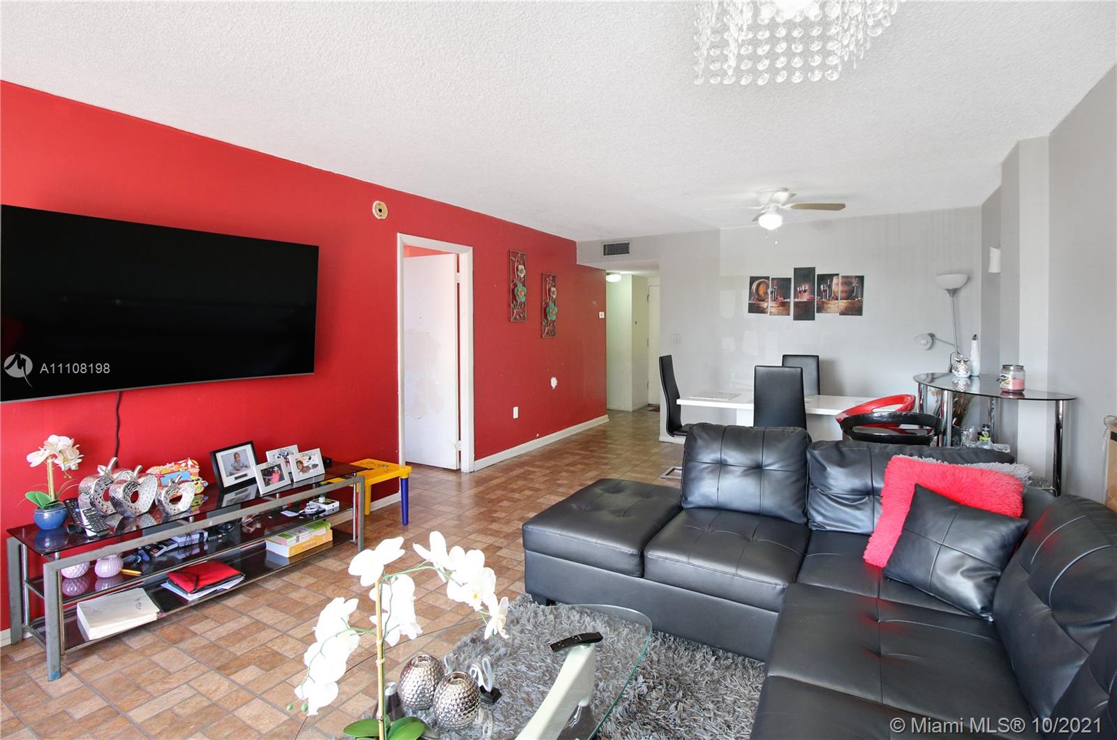 15600 Northwest 7th Avenue, Unit 3011 Miami, FL 33169 - Photo 6 of 30 a living room with furniture a flat screen tv and a window