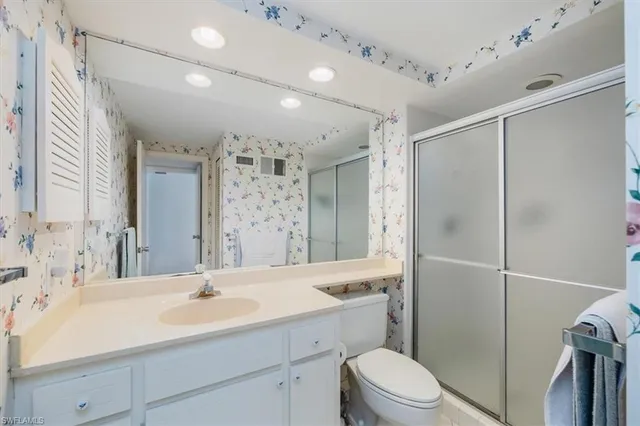 a bedroom with two beds and large windows