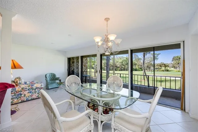 a dining room with furniture a chandelier and glass door