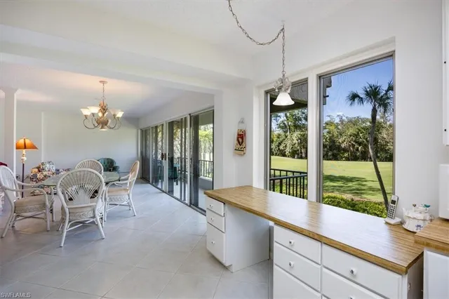 a dining room with furniture a chandelier and window