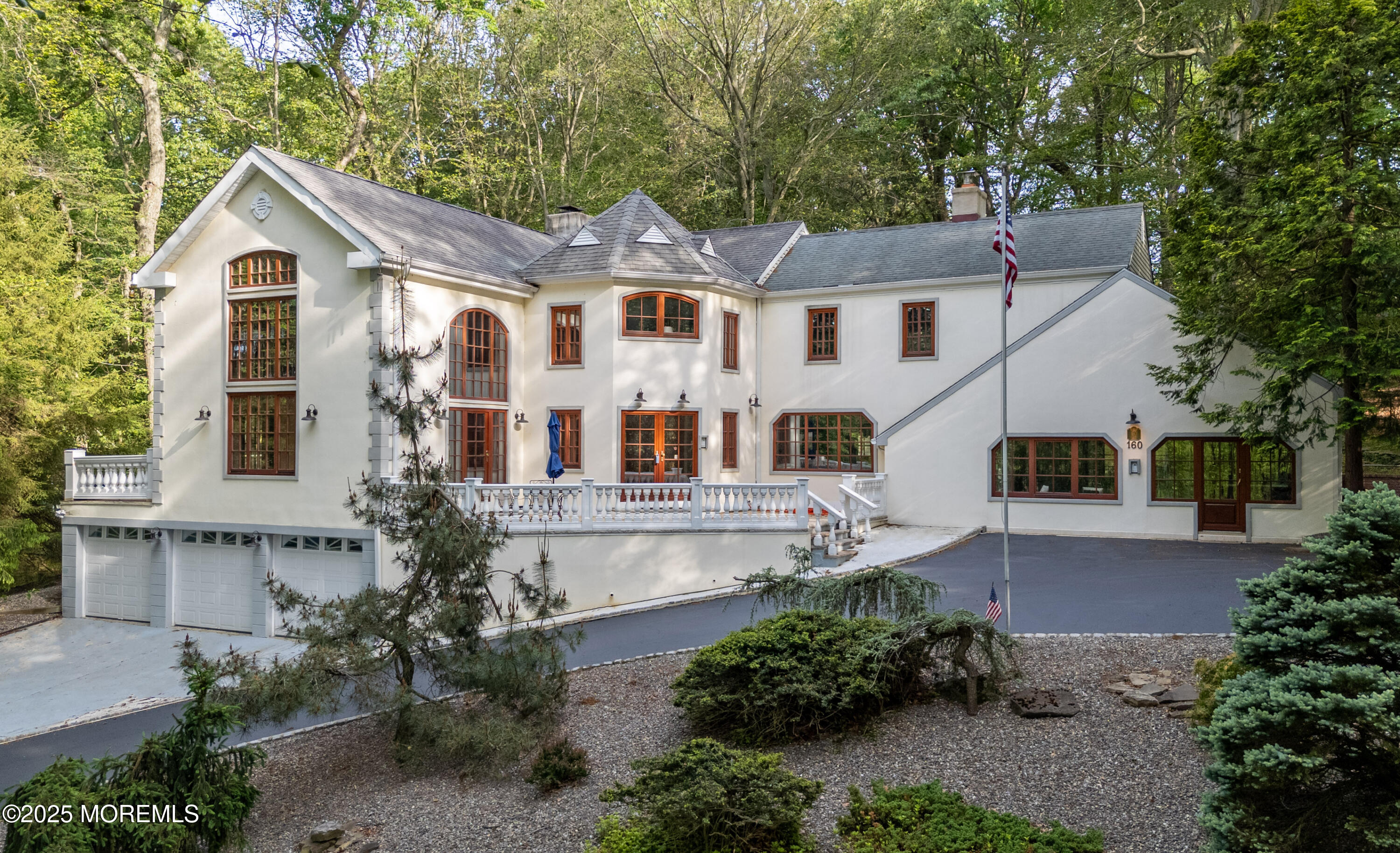 a view of a white house with a yard and potted plants