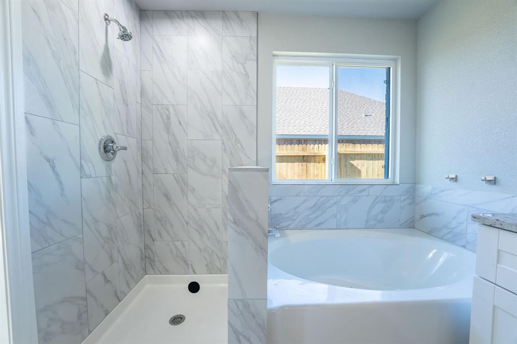 1032 Springview Lane Mabank, TX 75147 - Photo 7 of 15 Bathroom with a garden tub, vanity, and a marble finish shower