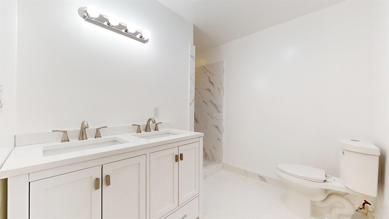 604 4th Street Hoboken, NJ 07030 - Photo 17 of 30 a bathroom with a sink a toilet and a mirror