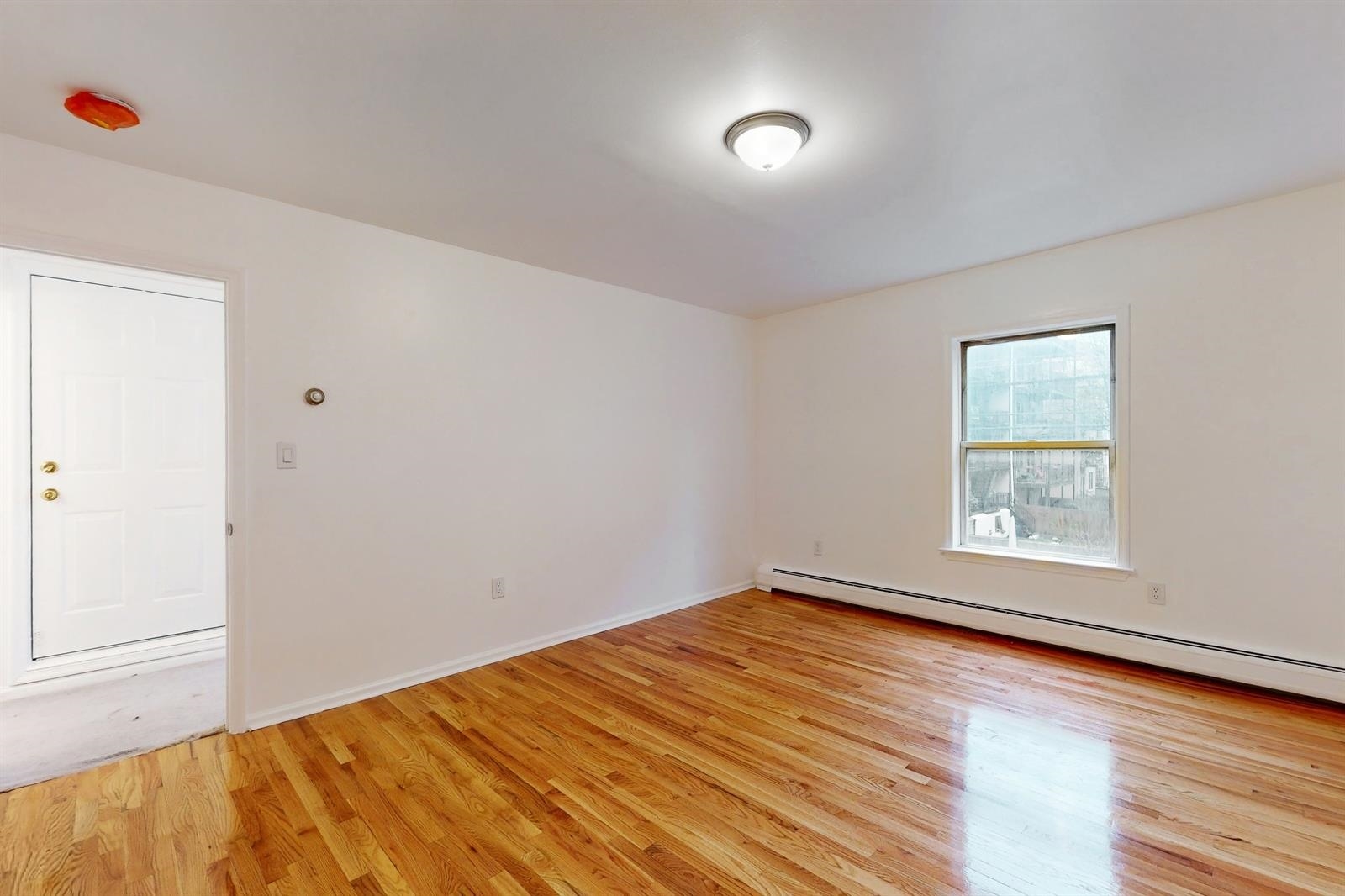 604 4th Street Hoboken, NJ 07030 - Photo 23 of 30 an empty room with wooden floor and windows