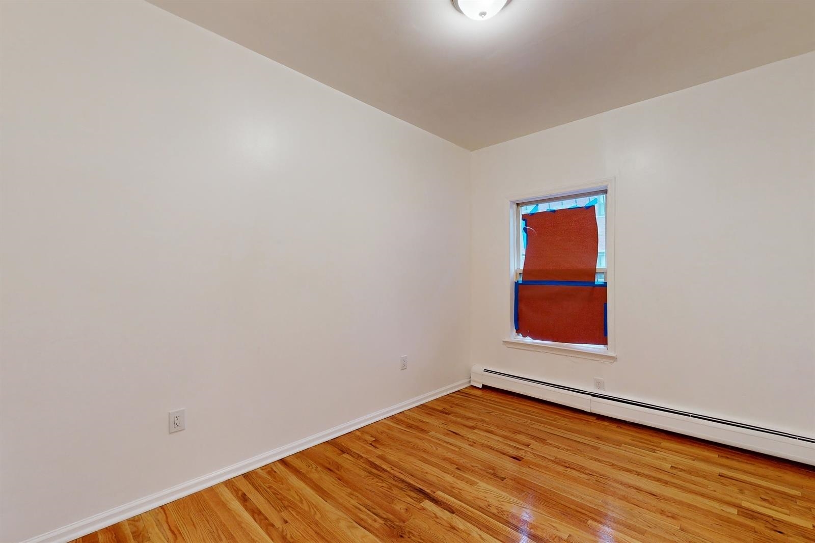 604 4th Street Hoboken, NJ 07030 - Photo 8 of 30 a view of an empty room with wooden floor and a window