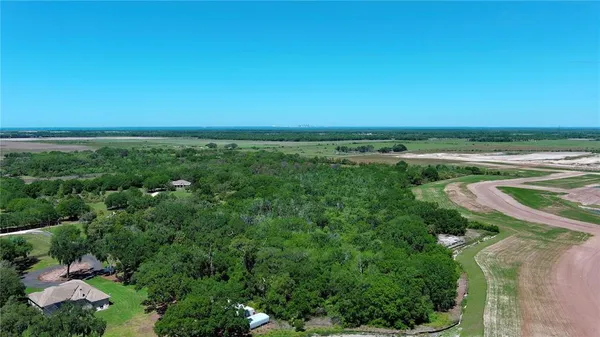 an aerial view of residential houses with outdoor space and trees