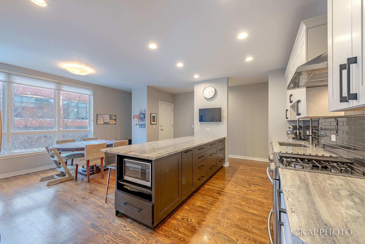 27 North Racine Avenue, Unit 432 Chicago, IL 60607 - Photo 8 of 28 a large white kitchen with stainless steel appliances granite countertop a stove and a view of living room