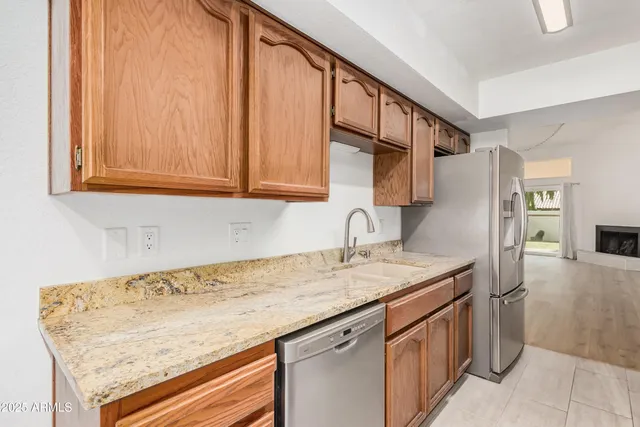 a utility room with stainless steel appliances granite countertop a sink and dishwasher